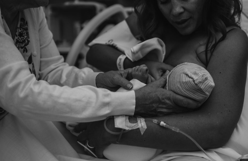 Birth photographer capturing Grandmother supporting mother with breastfeeding