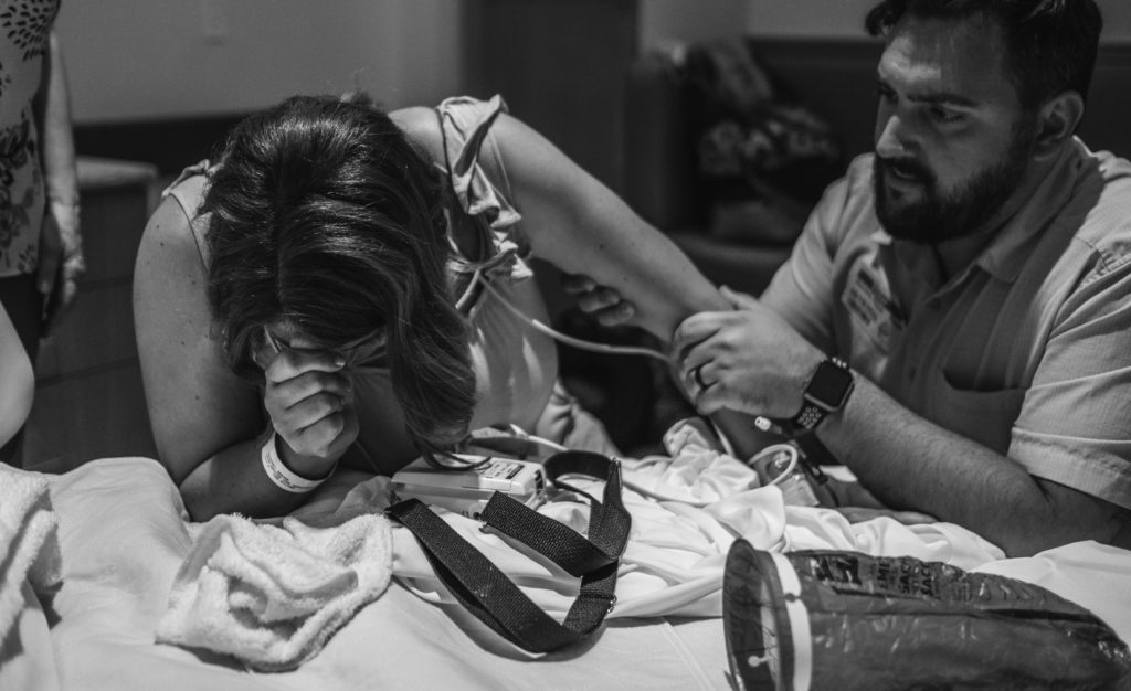 Husband supporting laboring mother during contractions 