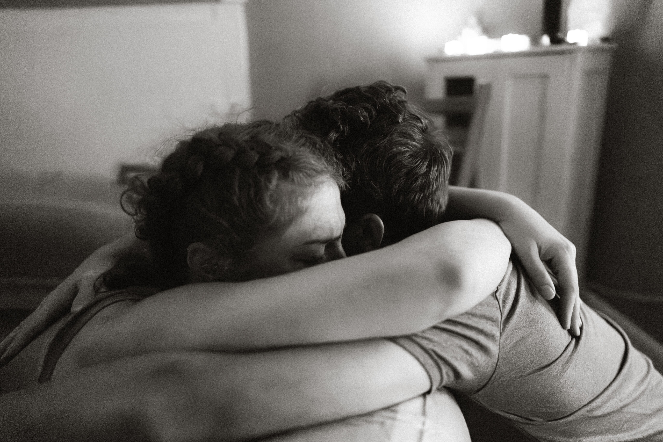 Husband and wife snuggling during contraction while mom is in home birth pool