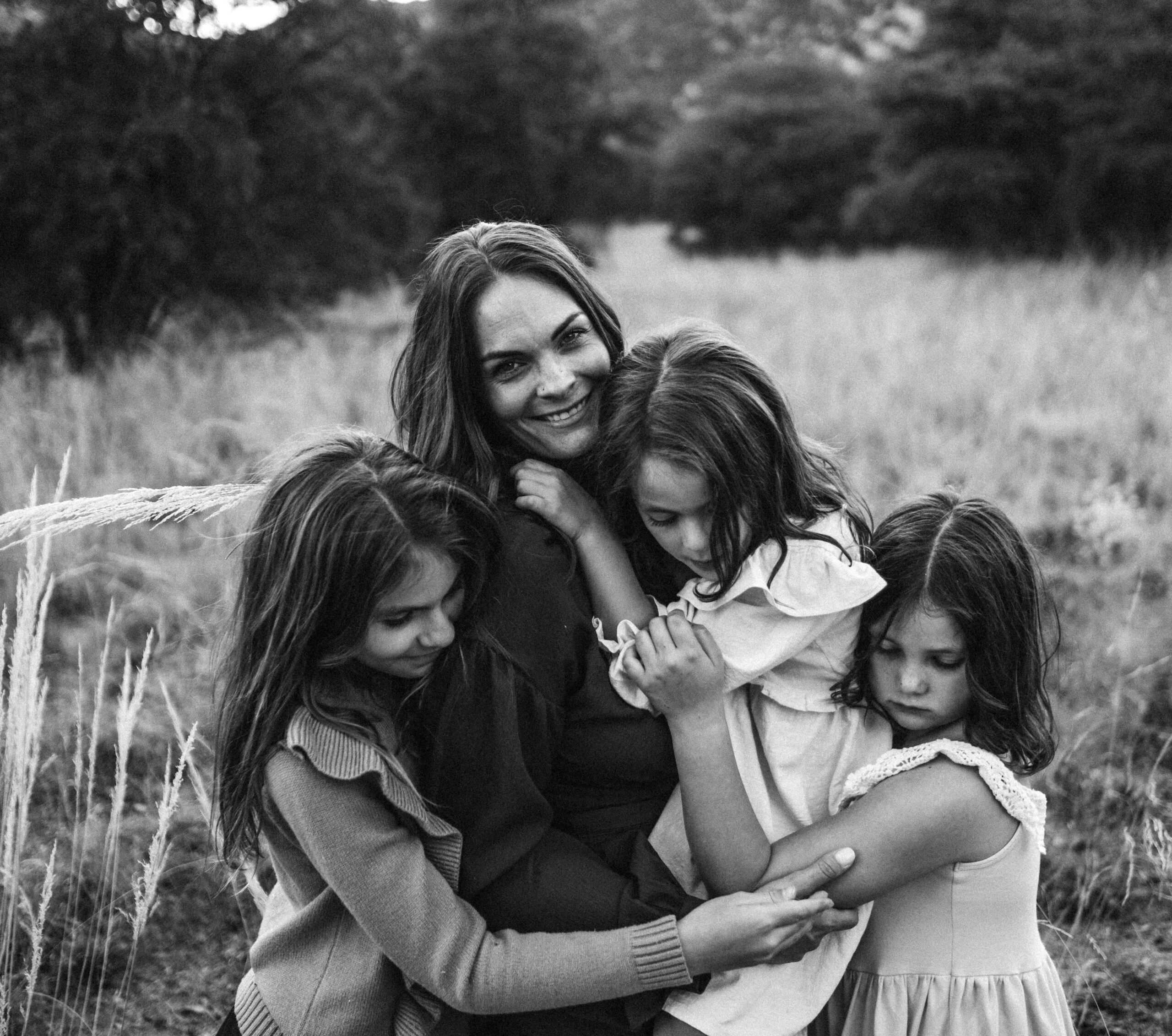 Mother and three daughters embracing during family session in Kansas City