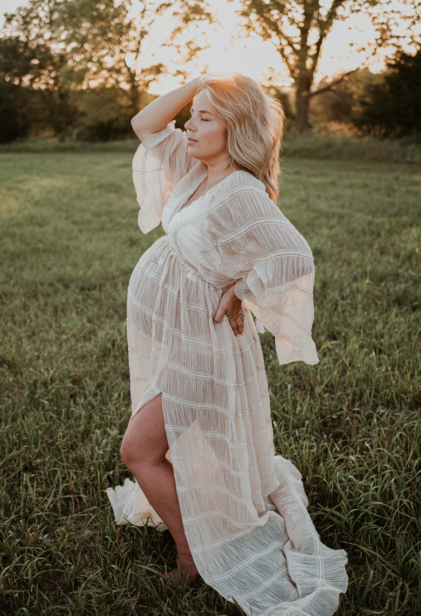 Pregnant mom standing with all her pregnant glow in Kansas City field